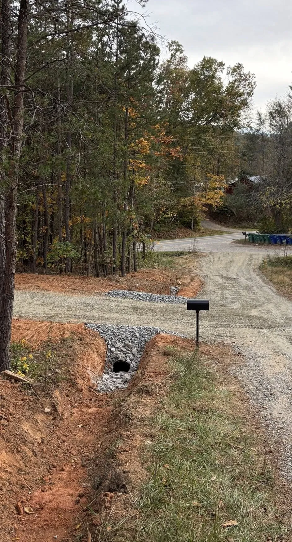 Driveway entrance with a stone-lined culvert and drainage swale newly installed
